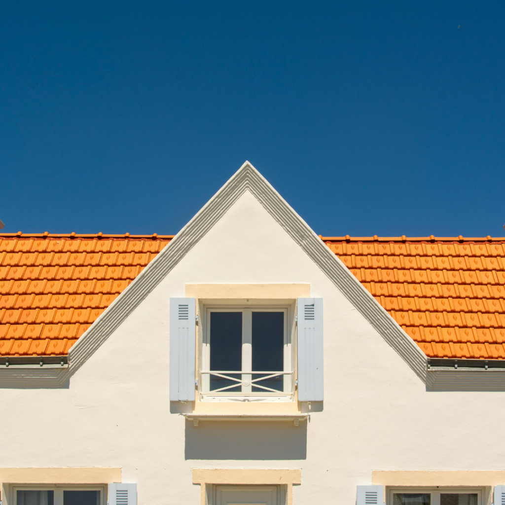 Toiture en tuile orange devant un ciel bleu - Les Belles Toitures Françaises