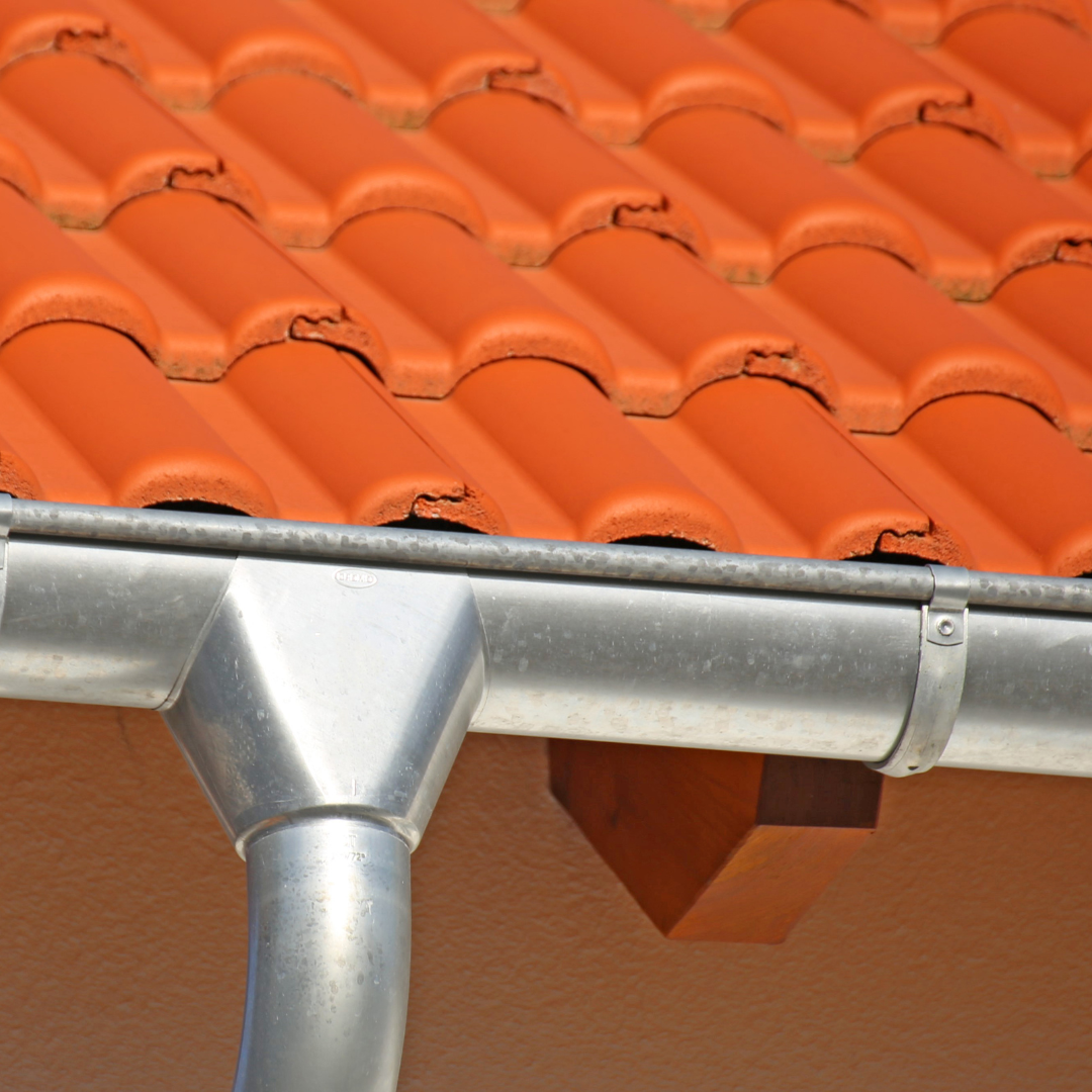 Gouttière en alu posée sur un toit en brique rouge - Les Belles Toitures Françaises