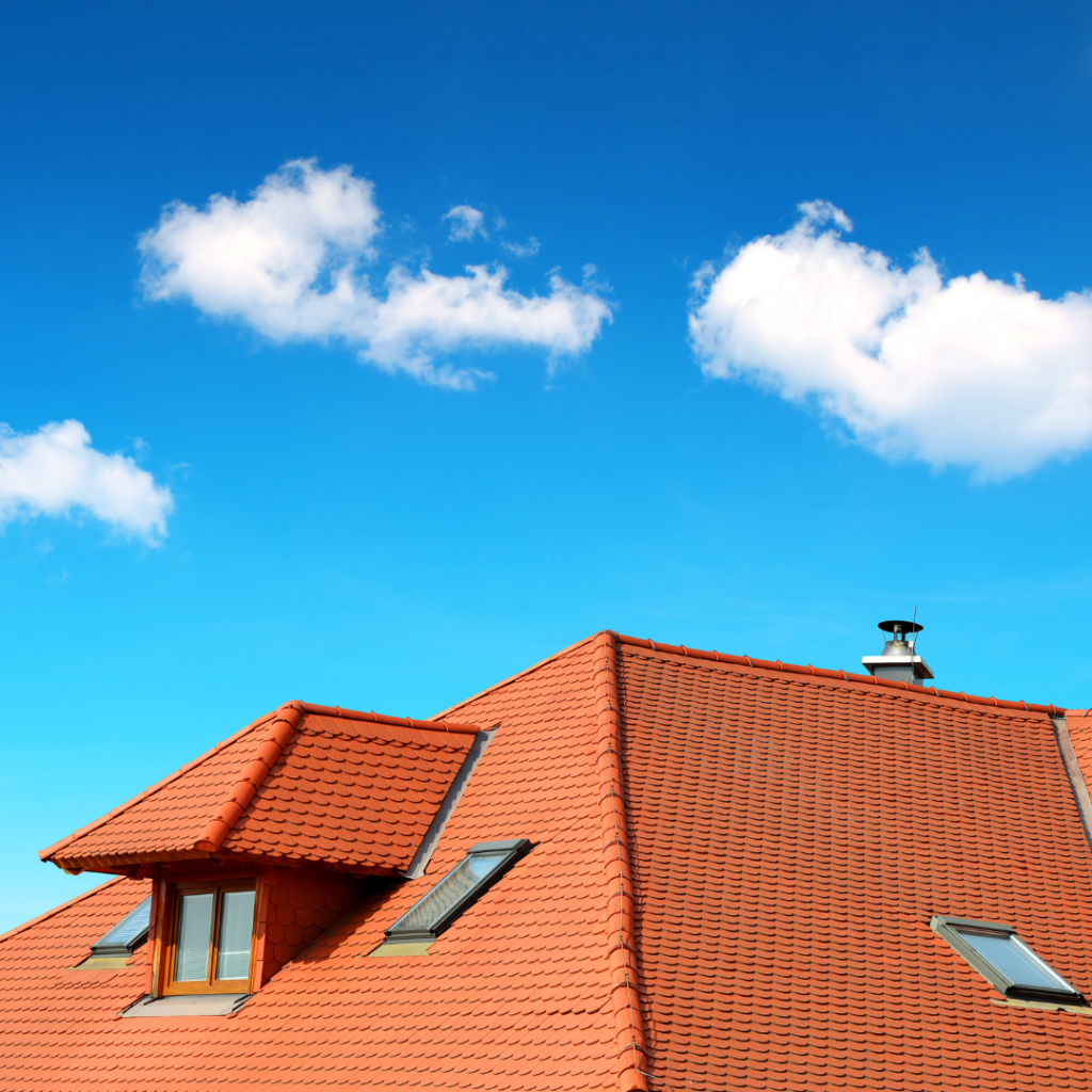 Toit en brique rouge avec un ciel bleu en arrière plan - Les Belles toitures Françaises 